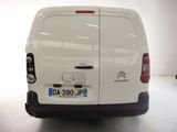 the back of a white van parked in a white room