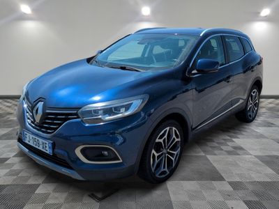 un SUV Renault bleu garé sur un sol à damier dans un garage