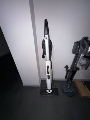 un aspirateur posé par terre près du mur