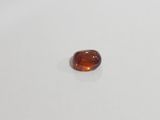 an oval shaped orange sapphire stone on a white surface