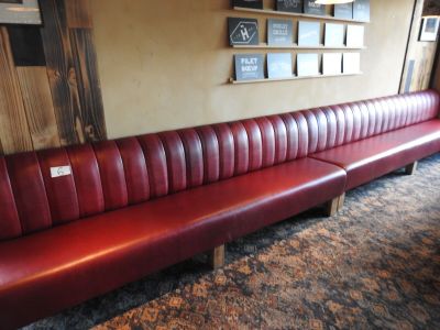une banquette en cuir rouge dans un coin d'un restaurant