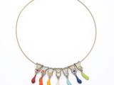 un collier auquel sont suspendues des gouttes de peinture multicolores