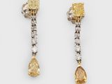 une paire de boucles d'oreilles en diamants jaunes et blancs