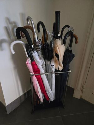 de nombreux parapluies posés dans un porte-parapluies en métal