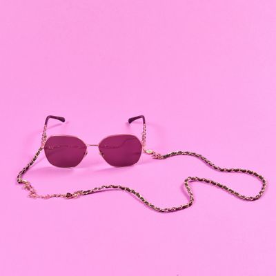 une paire de lunettes de soleil avec une chaîne, sur fond rose