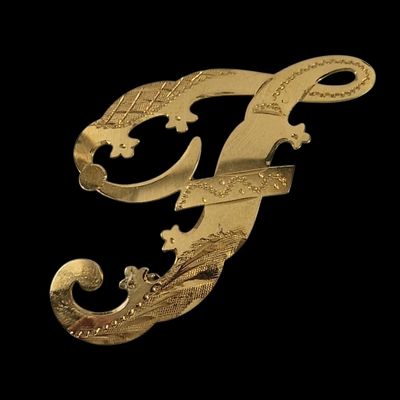 une image représentant la lettre « f » en doré sur fond noir