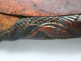 a close up of a wooden object with a leaf on it