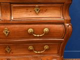 a wooden chest of drawers on a carpeted floor