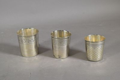 three silver cups sitting on top of a table next to each other