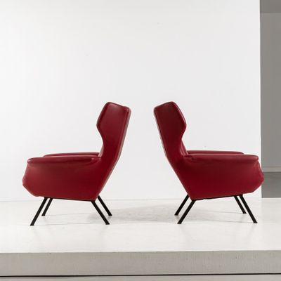 two red chairs sitting on top of a white surface
