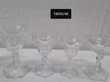 four wine glasses sitting on a table with a sign above them