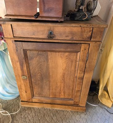 a wooden cabinet with a sewing machine on top of it