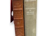 two books are stacked on top of each other on a white surface