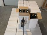 une pile de cartons et une bouteille de vin posés sur une table