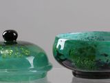 two glass bowls sitting on a table with a glass lid