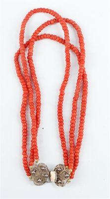 un collier de perles orange muni d'un fermoir en argent