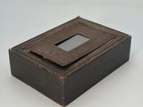 une vieille boîte en bois dotée d'une vitre, posée sur une surface blanche