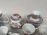 a lot of cups and saucers sitting on a table