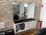 une photo d'un salon de coiffure avec un miroir accroché au mur