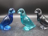 trois oiseaux en verre posés les uns à côté des autres sur une table