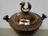 a brown pot with a bird on top of it