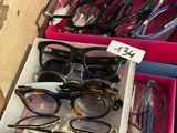 many pairs of glasses sitting in a pink box