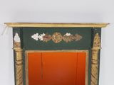 a green and gold fireplace with a red door