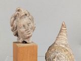 deux sculptures exposées sur une table en verre