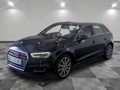 Une Audi noire est garée sur un sol à damier dans un garage