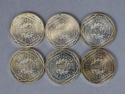 six pièces de monnaie différentes en livres sterling sont disposées en rangée sur une table