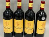 four bottles of red wine are lined up in a row