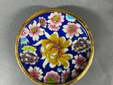 a close up of a small blue and yellow flowered box