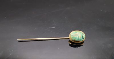 une photo d'une broche ornée d'une perle verte