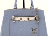 a close up of a blue handbag with a chain on it