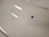 a white sink with a blue dot on it