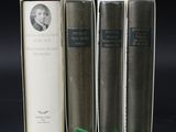 three books sitting on top of each other on a black surface