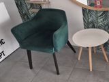 une chaise verte et une table blanche dans une pièce