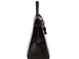 a black crocodile skin handbag on a white background
