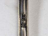 a spoon with a silver handle on a white table