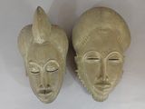 pair of carved wooden african masks on a white background