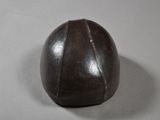 a brown leather ball sitting on a white surface