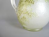 a white vase with a green floral design on it