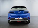 the rear end of a blue car in a showroom