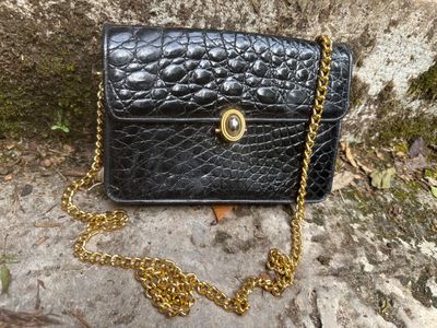 sac à main en cuir noir avec une chaîne dorée et une bandoulière en chaîne