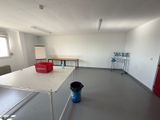une pièce avec une table et un seau posé par terre