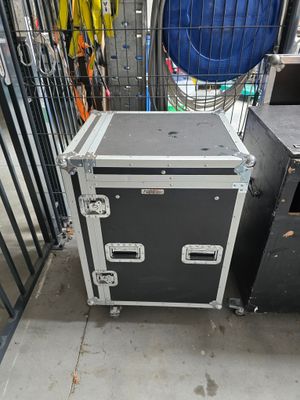 une valise noire et blanche posée par terre à côté d'autres objets