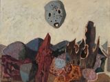 une peinture représentant un masque sur un mur, au-dessus d'un tas de pierres