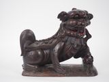 an image of a statue of a dog sitting on a rock