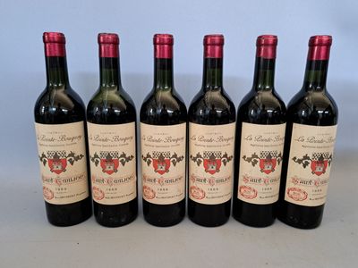 six bouteilles de vin sont alignées sur une table