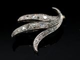 a close up of a diamond broochle on a black surface